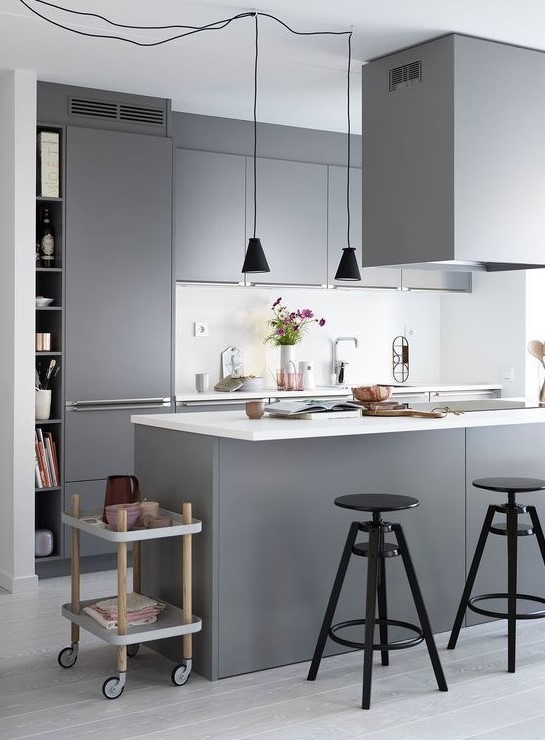  Pürüzsüz gri dolapları, beyaz tezgah ve arka planı, siyah sarkıt lambaları ve tabureleri olan çağdaş İskandinav mutfağı.