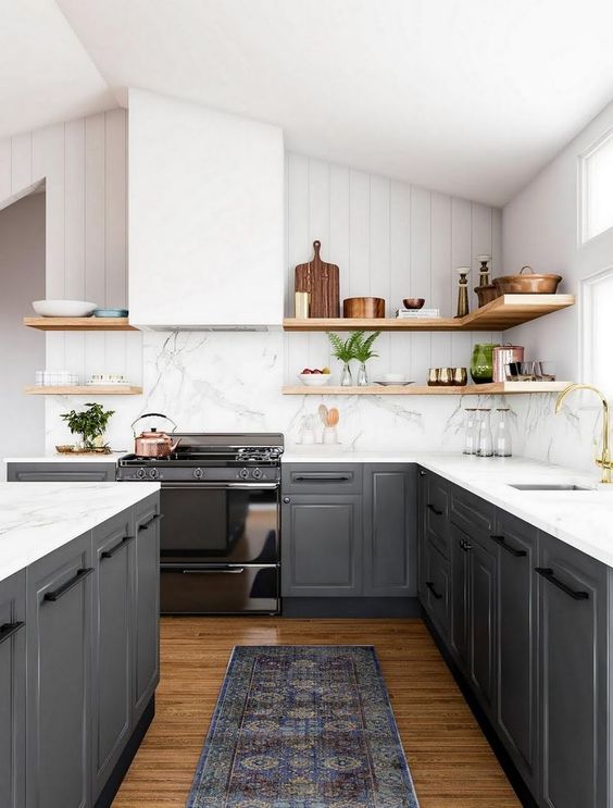 a gorgeous contrasting kitchen with graphite grey cabinets white countertops and a backsplash a hood wooden shelves for a softer look